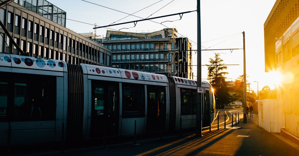 Nethack move past seemingly unpassable area - Tram riding on railroad on city street in summer in evening time near buildings