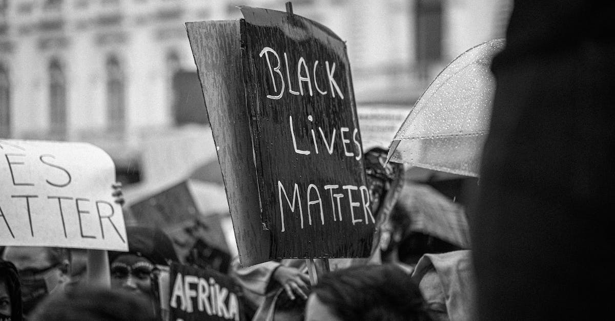 New campaign start - Black and white of anonymous demonstrators with cardboard placards during activist movement fighting for social justice and equality on street