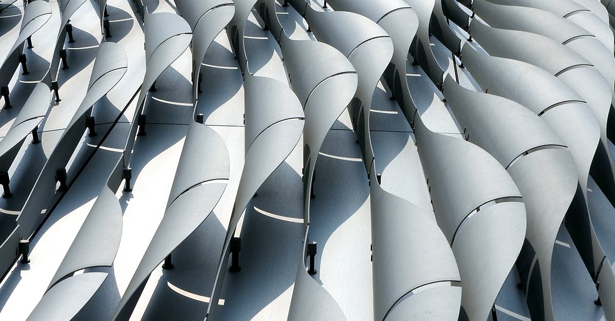 New liset segment - Curved ribs of gray color on wall of futuristic building shining in daylight New liset segment - Curved ribs of gray color on wall of futuristic building shining in daylight
