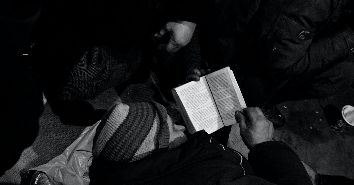 no corruption! I need help [duplicate] - Black and white of homeless man lying on floor and reading book in night shelter for homeless