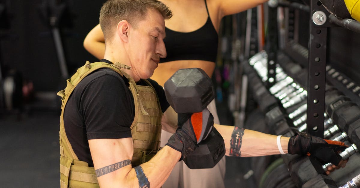 Not all duplicants are getting their "downtime" - Side View of a Man in a Weighted Vest Holding a Dumbbell