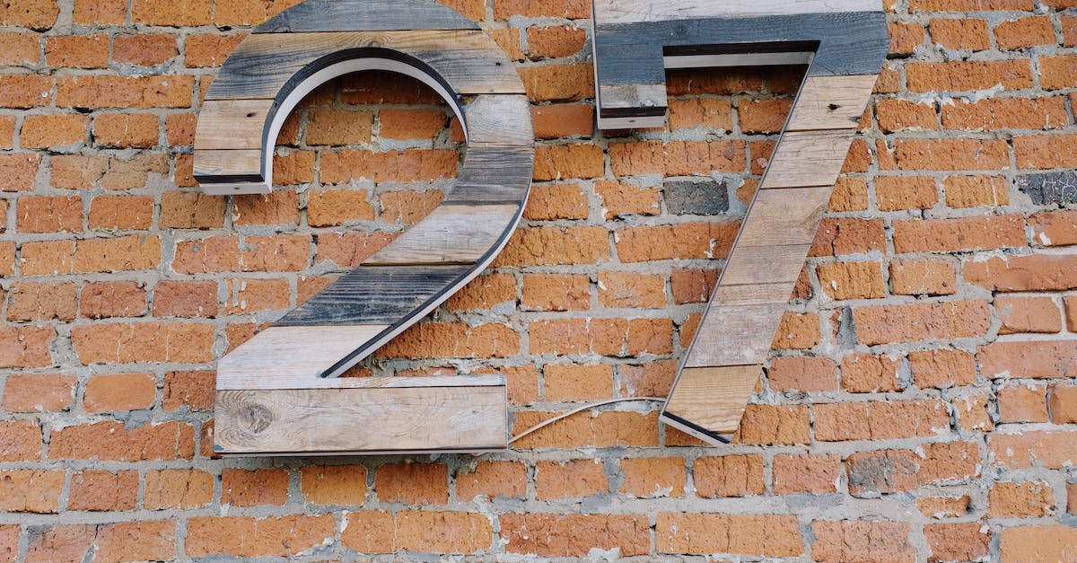 Number of possible build combinations - Big wooden number sign hanging on brick wall of modern building