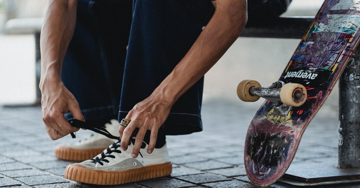 On what basis are tie-breakers decided in asphalt 8? - Crop young man tying shoelaces on white sneakers near skateboard