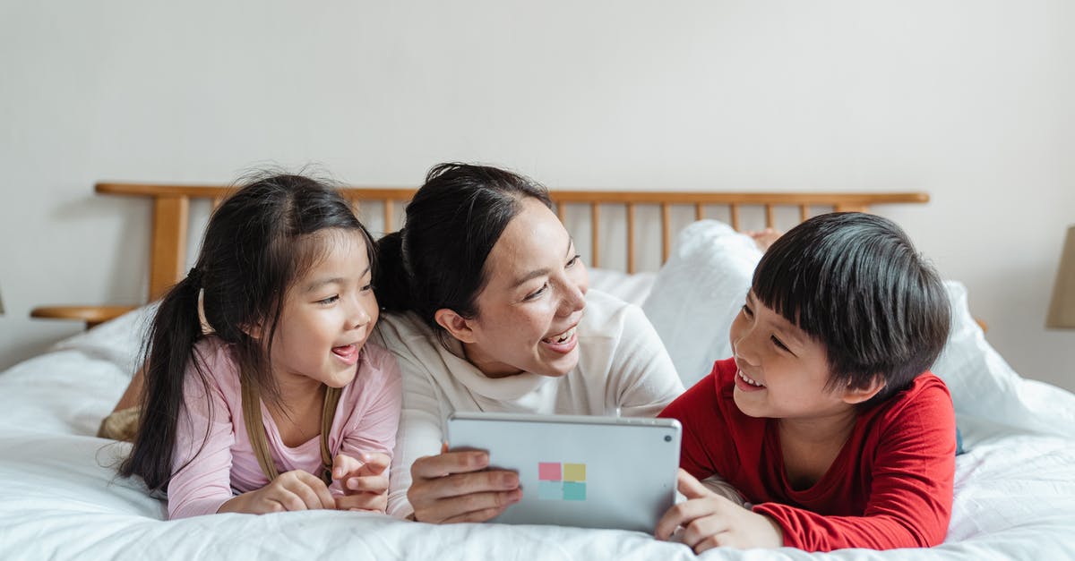 One son used other sons gmail account [duplicate] - Full body happy Asian female with smiling little children lying on belly in casual clothes on soft bed while using tablet in light apartment