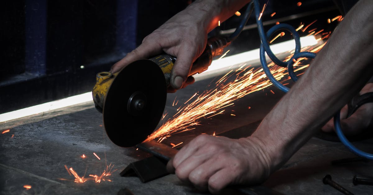 Order of technician calculation with accumulative power moves? - Crop unrecognizable male using angle grinder and cutting metal piece while working in garage