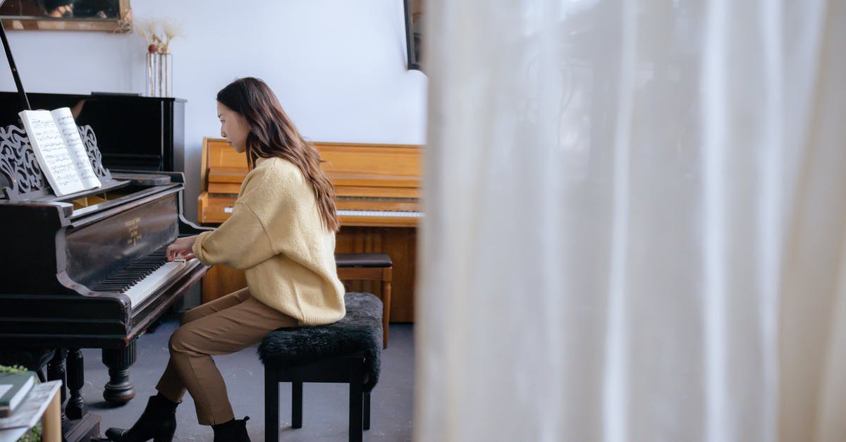 OSX FPS run key is toggle instead of press/relase - Full body of concentrated Asian lady in casual clothes and boots on high heels sitting on stool and gently touching piano keys and attentively looking at music book OSX FPS run key is toggle instead of press/relase - Full body of concentrated Asian lady in casual clothes and boots on high heels sitting on stool and gently touching piano keys and attentively looking at music book