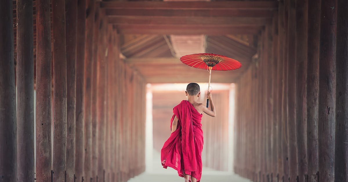 Parrying with the Monastery Scimitar - Boy Walking Between Wooden Frame While Holding Umbrella