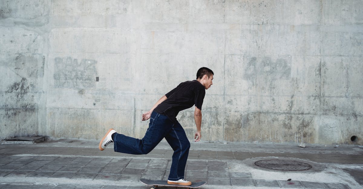Passing down an ability in Pokémon Black 2 - Full body side view of sportive male in black outfit riding on skateboard near stone wall on pavement in city Passing down an ability in Pokémon Black 2 - Full body side view of sportive male in black outfit riding on skateboard near stone wall on pavement in city