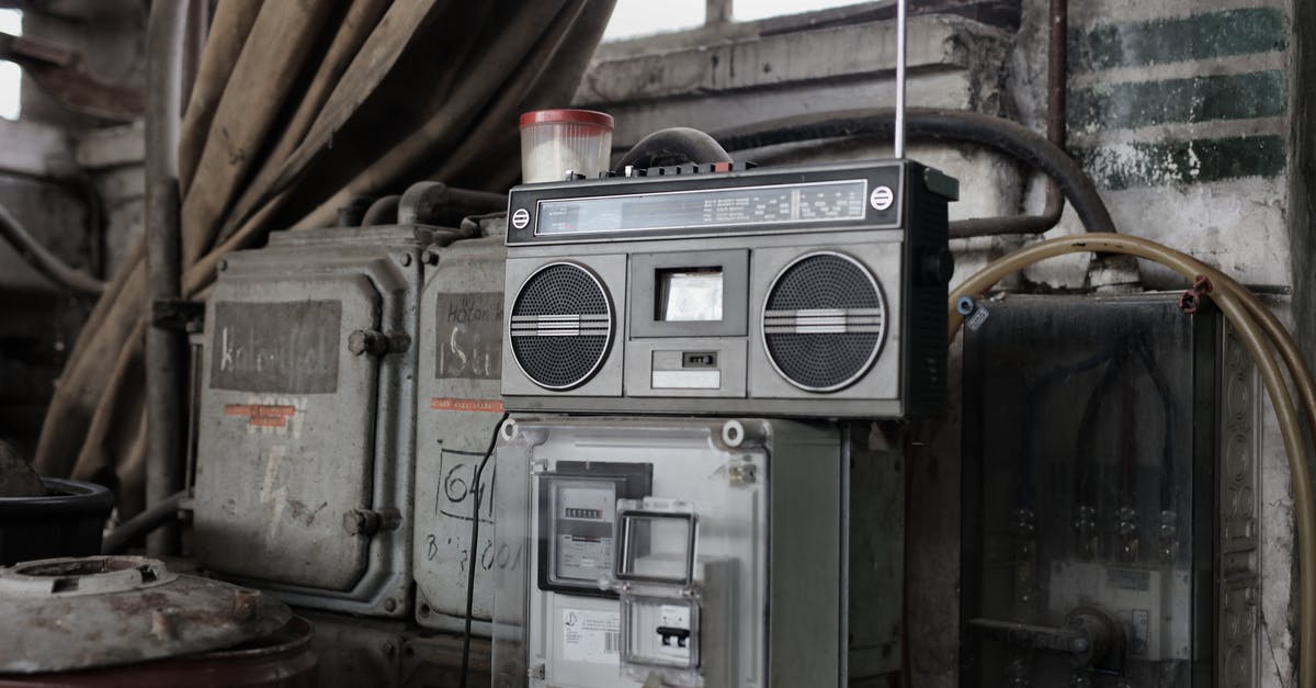 Penalty of removing facility - Old fashioned cassette player placed in shabby garage near old industrial equipment Penalty of removing facility - Old fashioned cassette player placed in shabby garage near old industrial equipment
