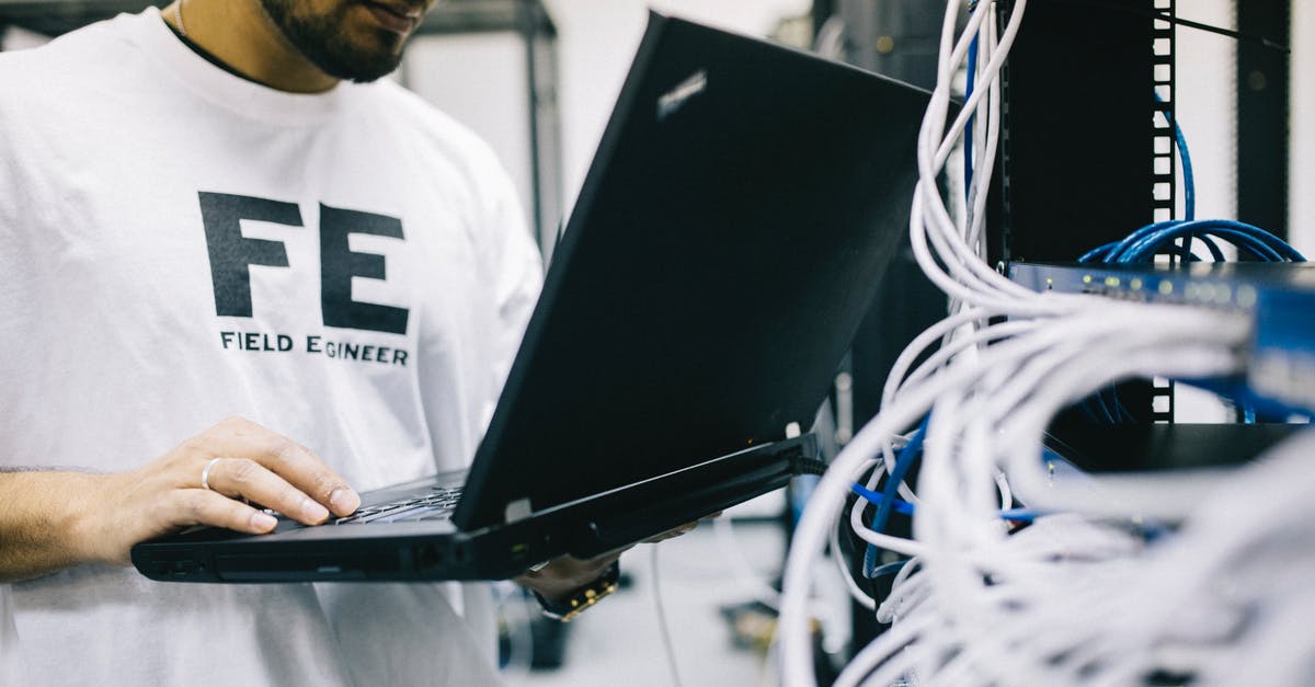 Pewdiepie's tuber simulator network under maintenance - Crop focused Asian engineer in white shirt using modern netbook while working with hardware