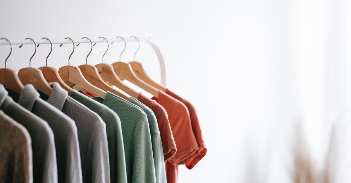 Pilot won't wall run, but rather wall hangs - Interior of light apartment with different clothes on wooden hangers in wardrobe near white walls