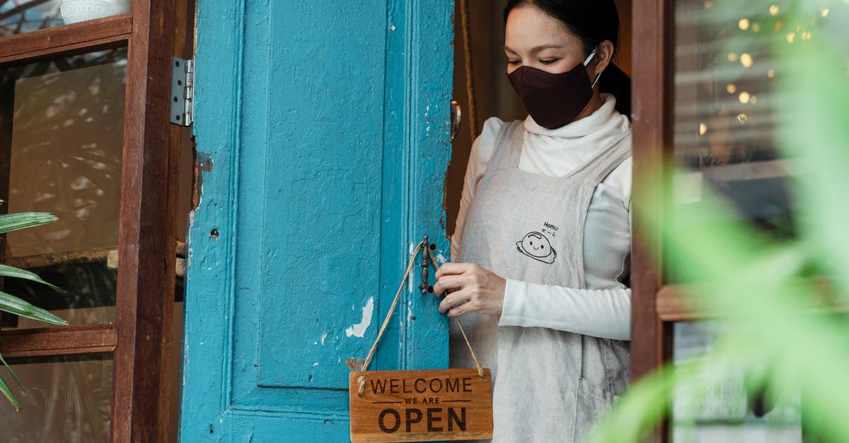 Placing a chest so it faces a specific direction - Photo of Woman Putting Wooden Welcome Sign on Doorknob