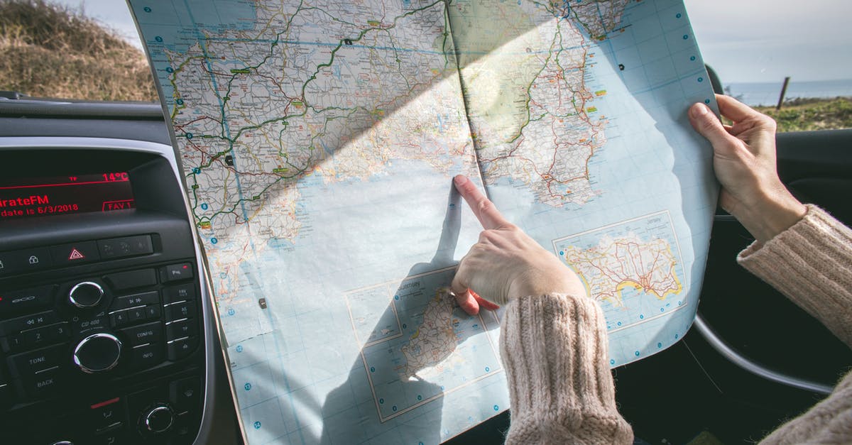 Placing Maps in Minecraft - Person Wearing Beige Sweater Holding Map Inside Vehicle