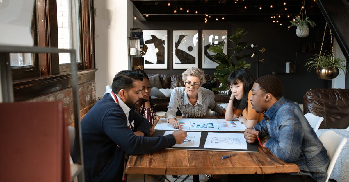 Planning and analyzing lighting layout - People in a Meeting Discussing Documents