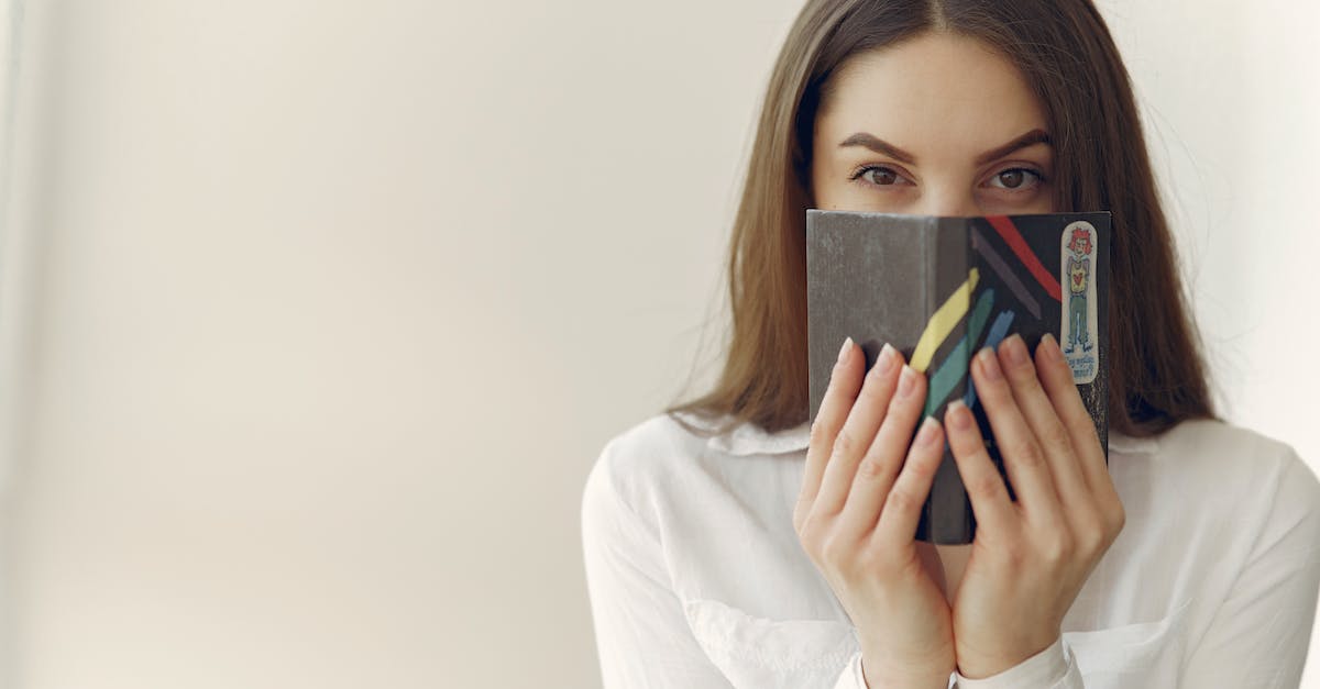 Play secret of mana or zombies ate my neighbors on wii U? - Charming woman covering face with notebook in office Play secret of mana or zombies ate my neighbors on wii U? - Charming woman covering face with notebook in office