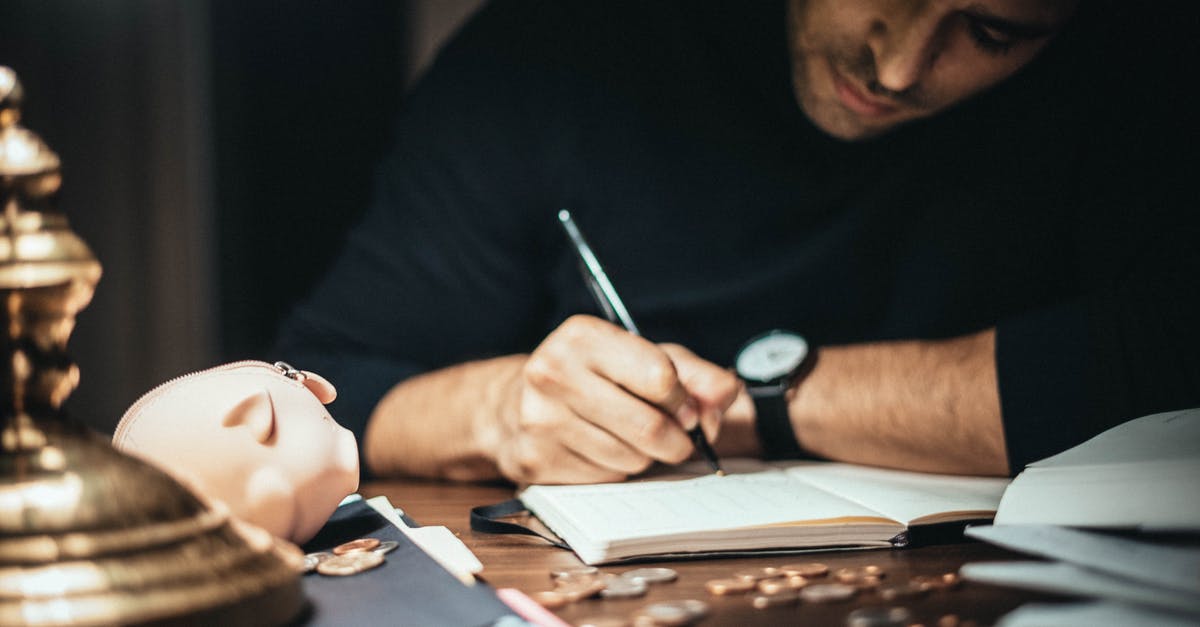 Playstation Plus account for a *child* account? (PS4) - Crop elegant man taking notes in journal while working at desk with coins and piggybank in lamplight