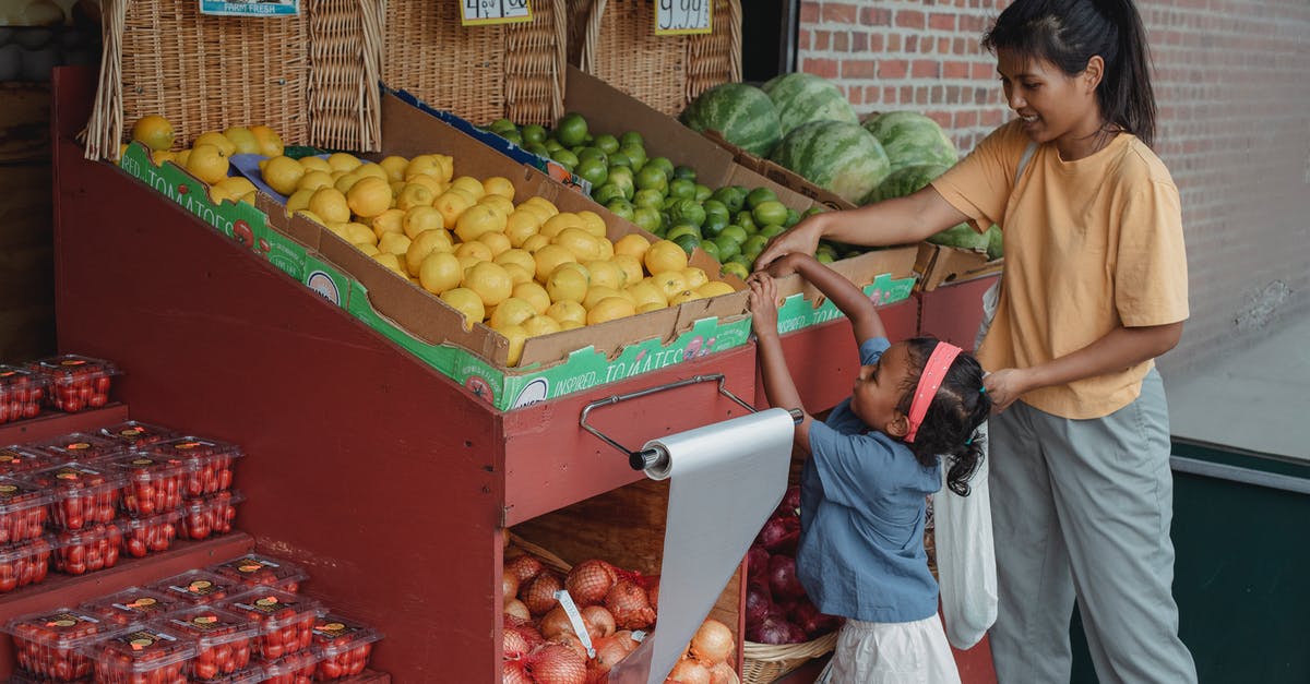 Playstation store Destiny help [duplicate] - Small ethnic girl taking fruits from box with mother