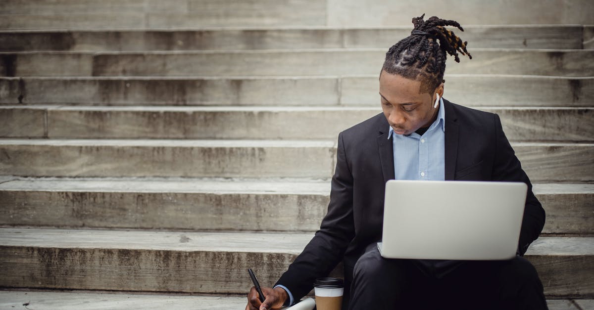Pokémon Go doesn't work on data - Concentrated young black man with dreadlocks in elegant suit browsing laptop and writing out information in notebook while sitting on stairs with takeaway coffee Pokémon Go doesn't work on data - Concentrated young black man with dreadlocks in elegant suit browsing laptop and writing out information in notebook while sitting on stairs with takeaway coffee