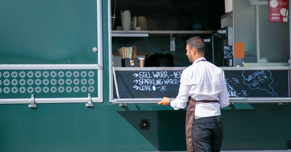 Pokémon Go: Thrown back to gym menu as soon as countdown ends - Back view of male seller wearing apron preparing food truck with menu written on board
