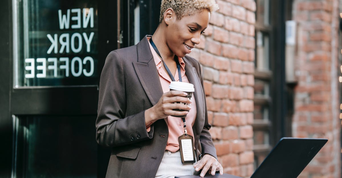 Pokemon Go crashes on startup? - Positive African American businesswoman with cup of coffee browsing netbook in outdoor cafeteria while working remotely Pokemon Go crashes on startup? - Positive African American businesswoman with cup of coffee browsing netbook in outdoor cafeteria while working remotely
