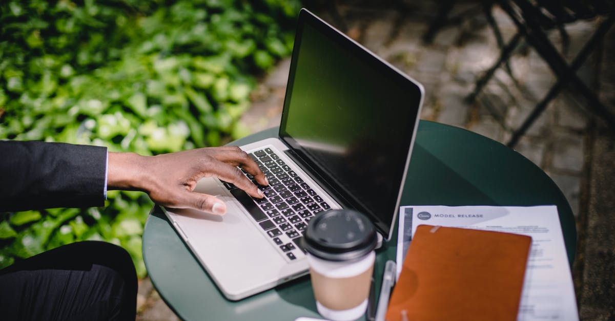 Pokemon Go Data Lost - Crop anonymous black male freelancer working on netbook in park cafe