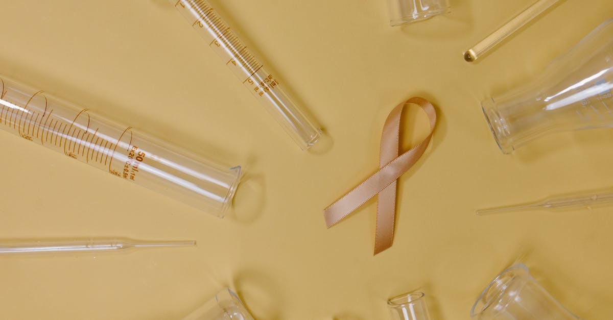 Portal 2 Authoring tools problem - Top view of pink ribbon representing cancer placed on yellow background among glass test tubes and flasks in light studio Portal 2 Authoring tools problem - Top view of pink ribbon representing cancer placed on yellow background among glass test tubes and flasks in light studio