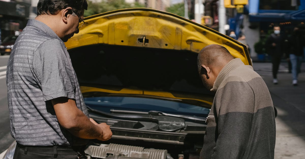 Portal 2 Authoring tools problem - Ethnic mechanic checking car standing near man Portal 2 Authoring tools problem - Ethnic mechanic checking car standing near man