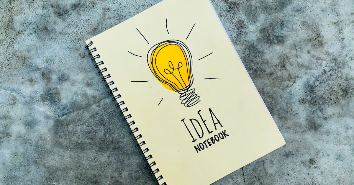 Powering a Redstone Lamp on top of a Piston - Top view of creative spiral notebook with yellow light bulb illustration on cover placed on gray table