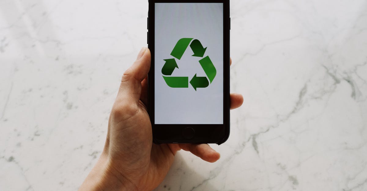 Prevent AI from using Venice - From above view of faceless person holding mobile phone with white screen and green recycle logo above marble surface Prevent AI from using Venice - From above view of faceless person holding mobile phone with white screen and green recycle logo above marble surface