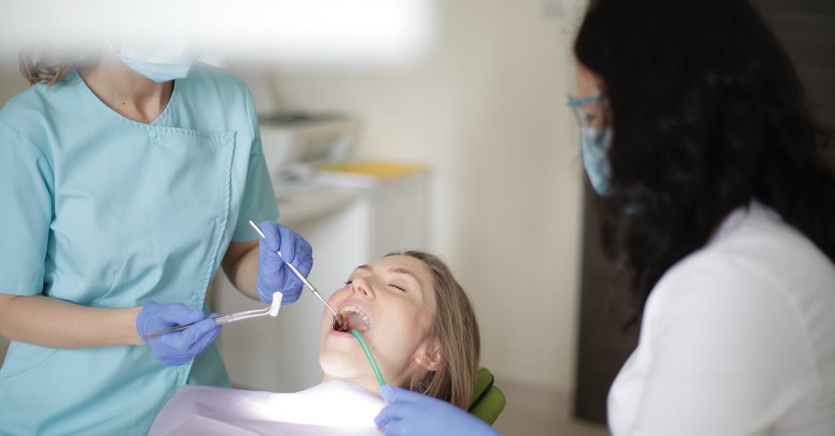 Prevent clients from using mods on a server - Crop faceless female dentist in blue uniform and latex gloves inserting cotton tampon to patient mouth while working with assistant and preparing patient for dental treatment Prevent clients from using mods on a server - Crop faceless female dentist in blue uniform and latex gloves inserting cotton tampon to patient mouth while working with assistant and preparing patient for dental treatment