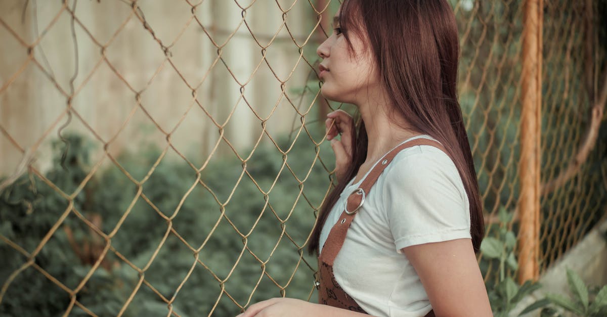 Preventing/negating Frenzy at Brain Ladies (posible spoilers) - Side view of young female thinking on escape while standing near fence in countryside