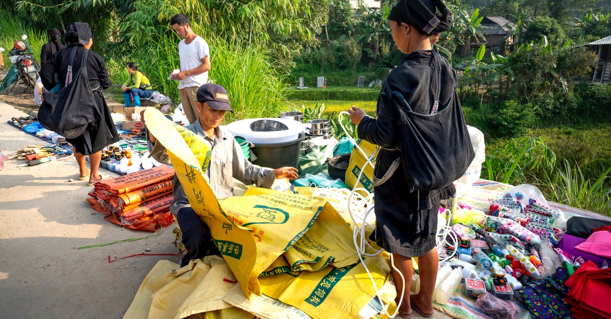 Problems with custom villagers and trading - Asian people standing near indigenous market with goods on ground Problems with custom villagers and trading - Asian people standing near indigenous market with goods on ground