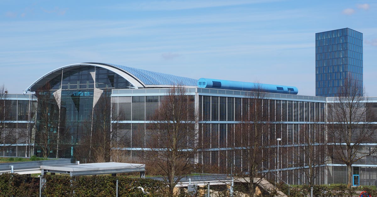 Production Buildings radius and placement - Gray and Blue Glass Building Surrounded by Bare Trees
