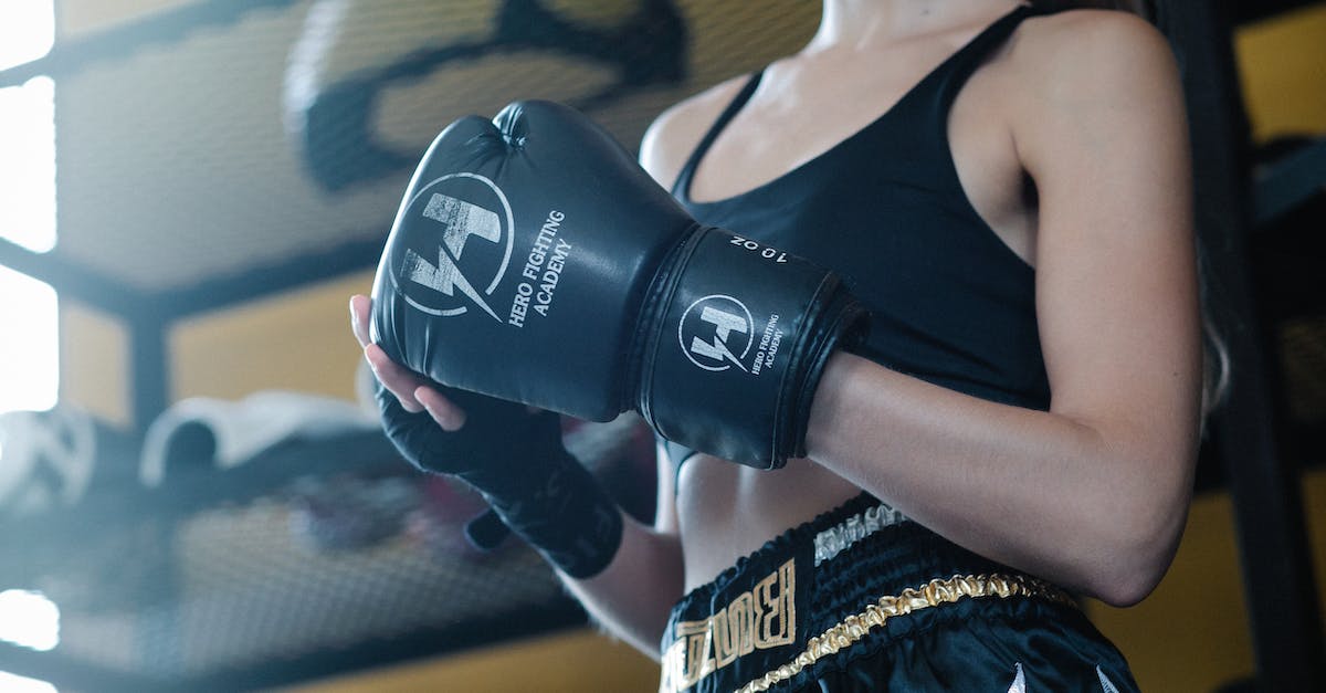 Protect Playstation from Power outage and Surges - From below of crop slim lady wearing activewear and boxing glove with bandages on hands in gym