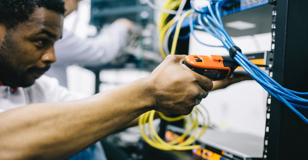 PS4 System Error after Updating - Crop focused ethnic engineer using electric screwdriver