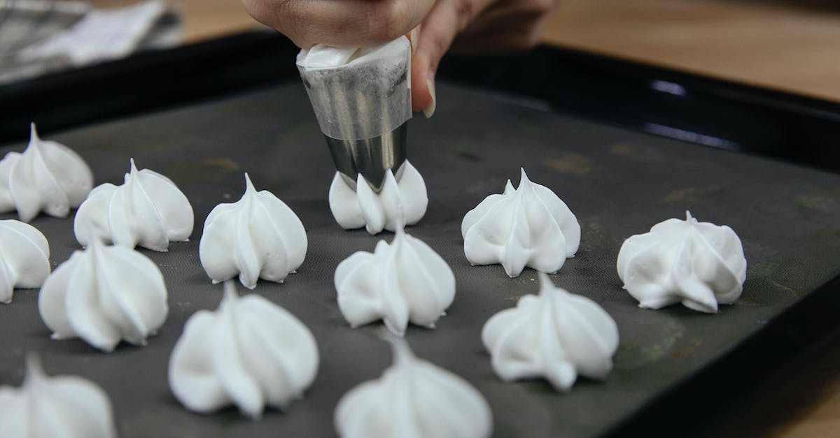 Putting out camping/cooking fires - Crop anonymous cook putting out meringue from pastry bag onto baking tray during cooking process