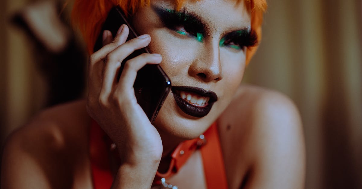 Quest 'Strange beast': Talk to Thorleif fails when you reach the ambush site - Crop young informal ethnic lady with bright makeup and short orange hair smiling while lying on stomach and talking on smartphone