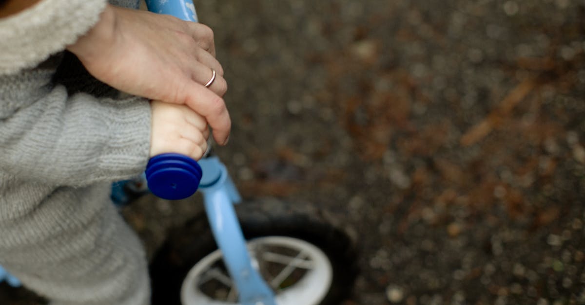 Quick way to move items from inventory to chest - From above unrecognizable crop father teaching little kid how to ride bicycle on wet asphalt road during walk together in autumn day