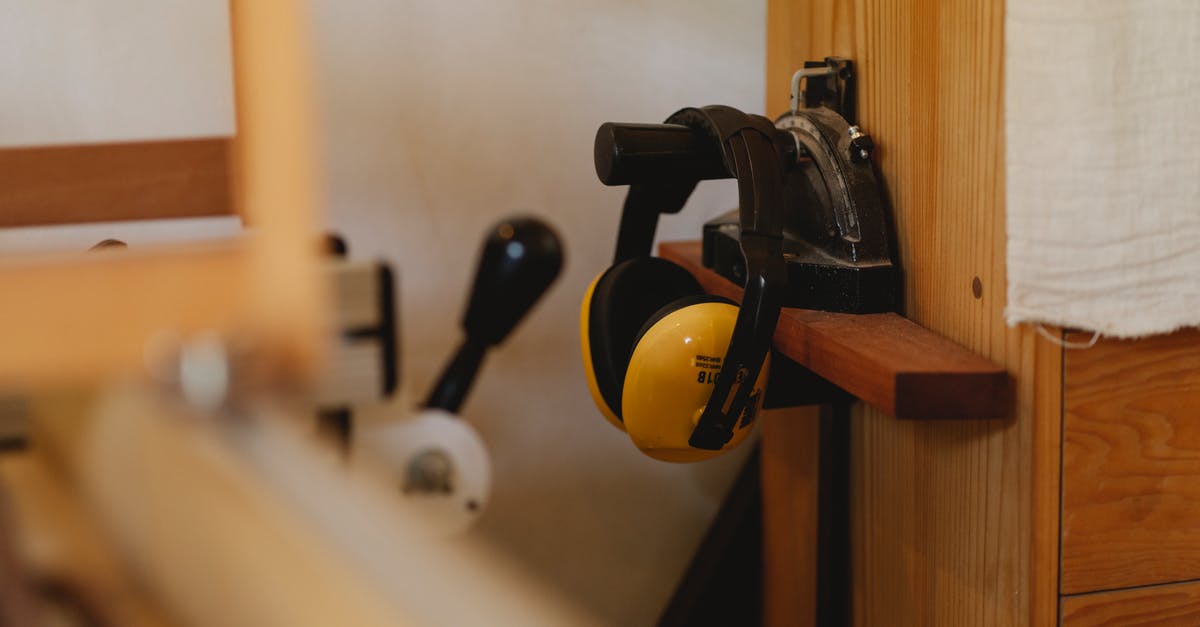 Quiet supply drops - Yellow noise cancelling headphones for carpentry work hanging on timber shelf in workshop