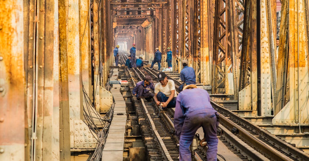 "There is no builder hero in the team." What is a builder hero? - Group of anonymous male technicians in dirty uniforms building railroad together in city