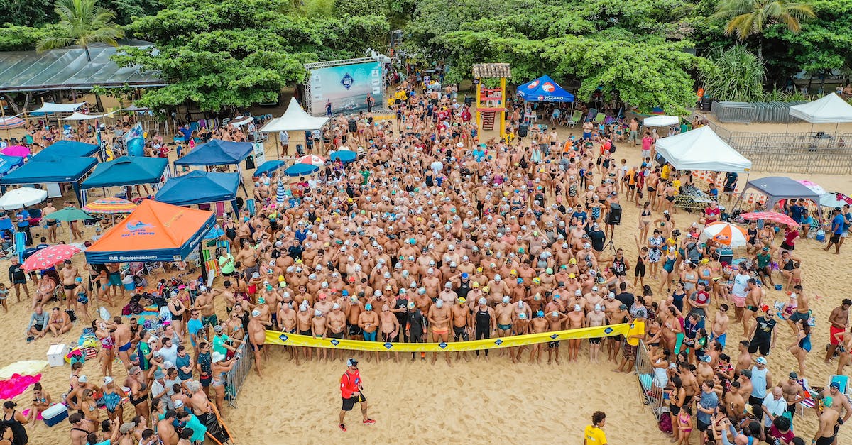Race Start Mode of Gran Turismo 5 - Drone view of sportive people in swimsuits standing behind line tape on seashore preparing for swim challenge in sea