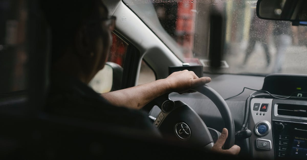 Rail traffic is backed up trying to leave my city. Is there anything I can do? - Back view of crop anonymous man in eyeglasses driving car in rainy day
