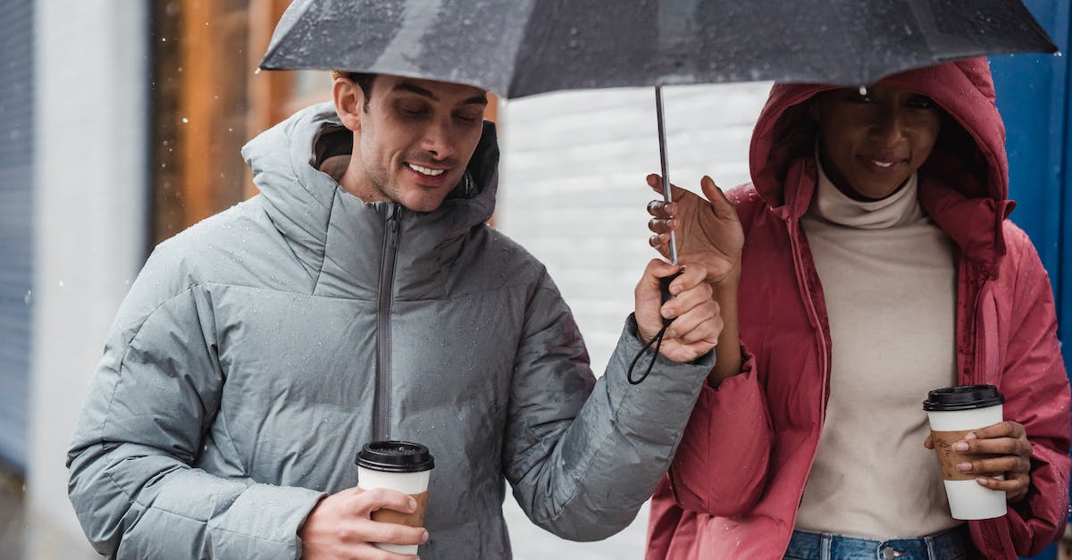 Rain arrows in random positions within bounds? [duplicate] - Smiling diverse couple walking with umbrella in rainy day