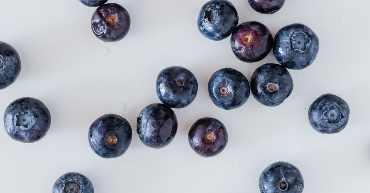 Random charges of tyranny - Top view of delicious ripe and sweet blueberry randomly scattered on white surface Random charges of tyranny - Top view of delicious ripe and sweet blueberry randomly scattered on white surface
