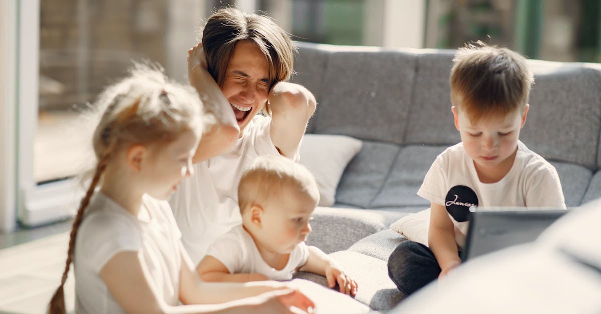 Realm of the Mad god is too laggy to play - Woman going mad while sitting with little kids playing together on sofa in well lit room Realm of the Mad god is too laggy to play - Woman going mad while sitting with little kids playing together on sofa in well lit room