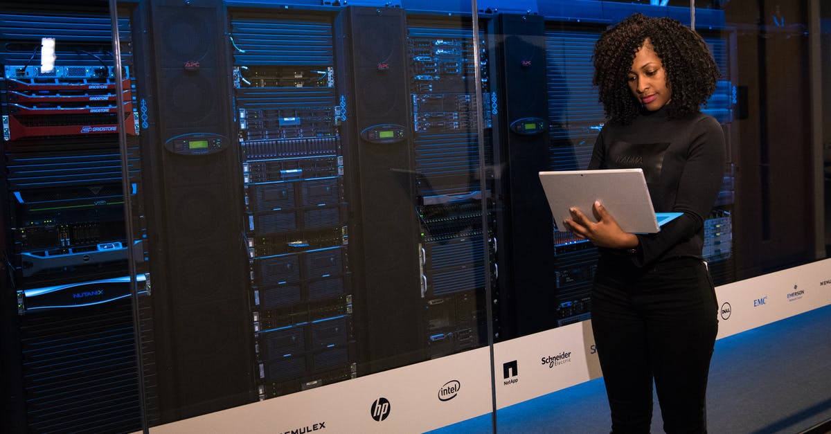 Rebuilding Database function in Playstation 3. - Software Engineer Standing Beside Server Racks Rebuilding Database function in Playstation 3. - Software Engineer Standing Beside Server Racks