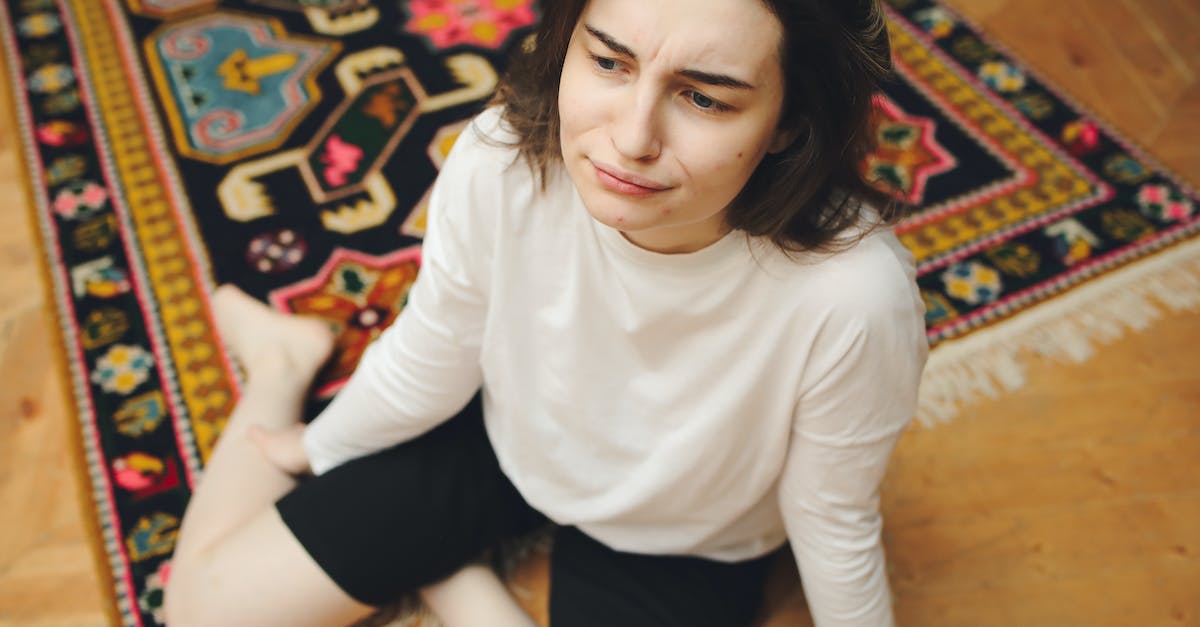 Recommended stats to face Malthael - Woman in White Long Sleeve Shirt and Black Shorts Sitting on Brown and Beige Floral Area