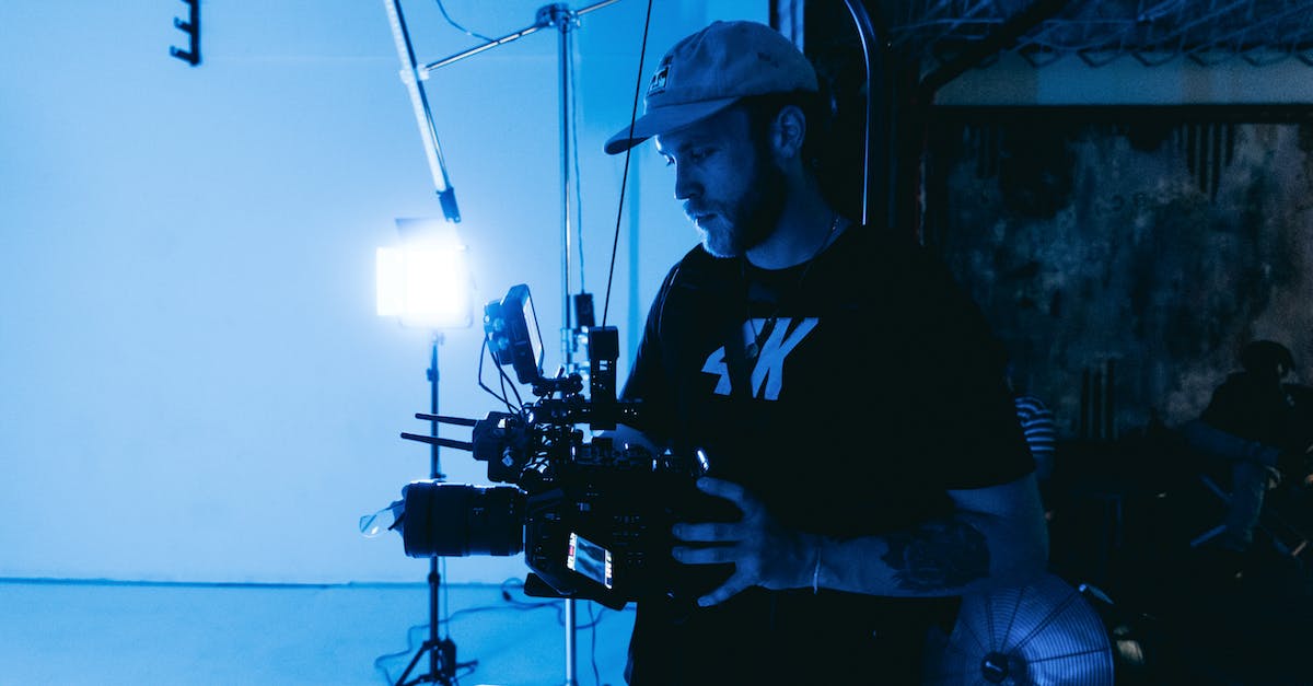 Recording at 60 FPS - Man in Black Crew Neck T-shirt Standing Near Black Camera Recording at 60 FPS - Man in Black Crew Neck T-shirt Standing Near Black Camera