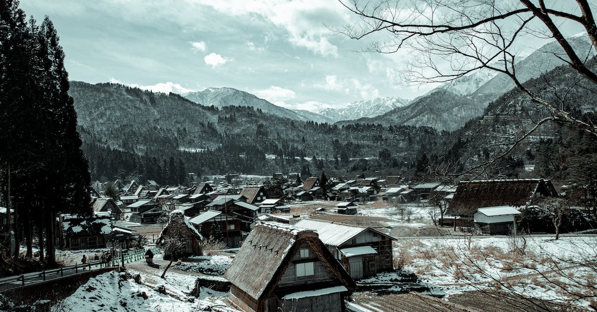 Recruiting from villages in Mount & Blade Warband - Viking Conquest - Village with houses near mountains in winter under cloudy sky