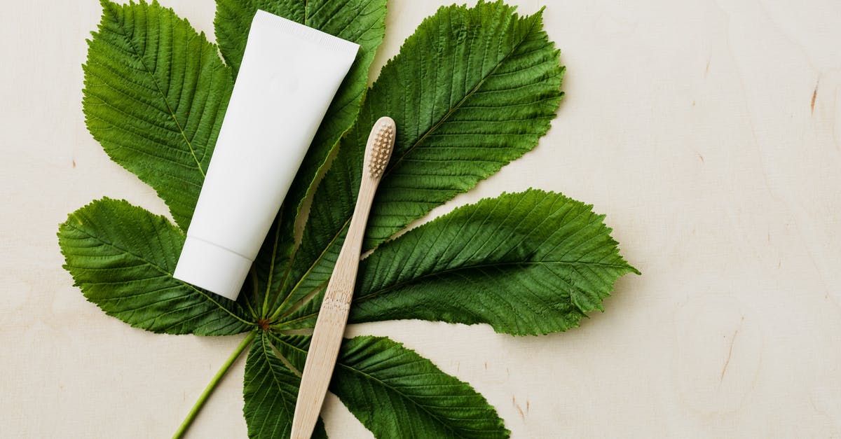 Reduce the four views to only two (1st and 3rd person) - Organic toothpaste tube and bamboo toothbrush on fresh green leaf